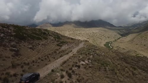 Drone: flies behind a car through a gorge in the mountains of Kyrgyzstan