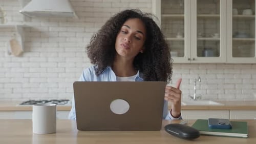Woman Communicating Online via Laptop in Kitchen