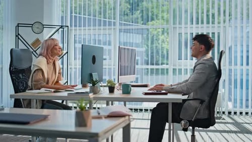 Business Colleagues Discussing Documents in Bright Office