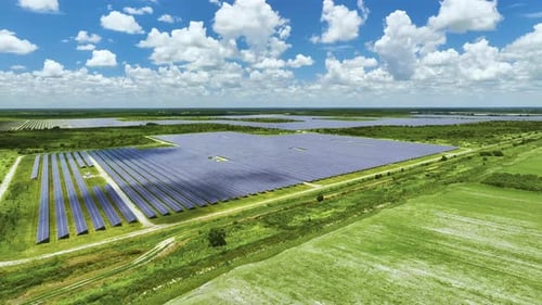 Aerial View of Sustainable Electrical Power Plant Between Agricultural Farmlands with Photovoltaic