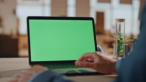 Person Works on Laptop with Green Screen