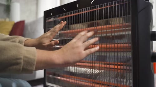 Cold hands are warming up in the heater.