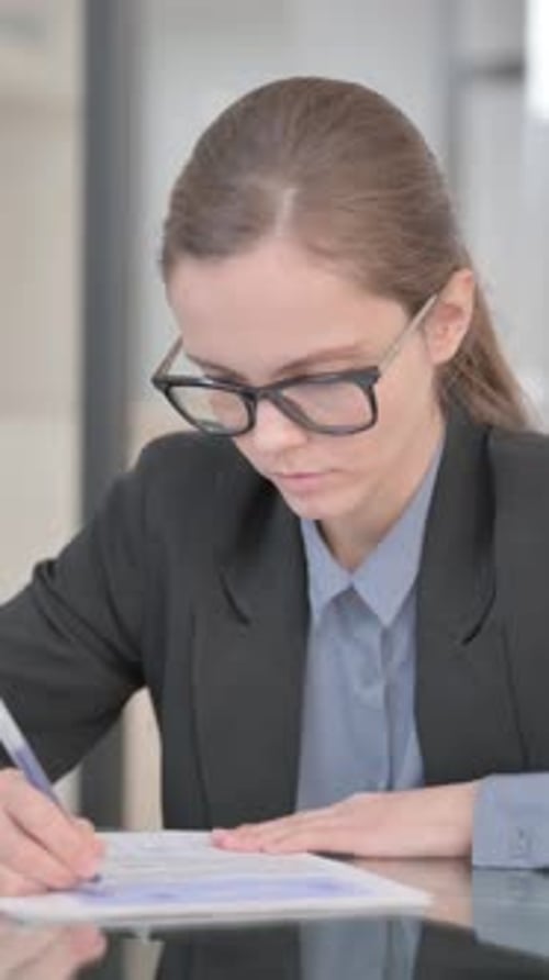 Businesswoman Doing Paperwork in Office, vertical video