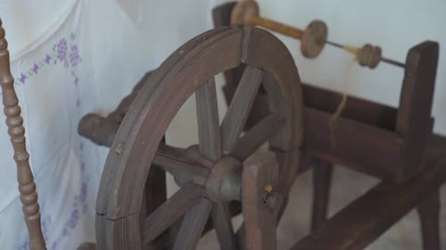 Old, vintage, antique spinning wheel in corner of old house. Close up parallax.