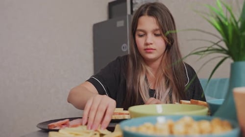 Teen Girl Makes Sandwiches in Kitchen at Home