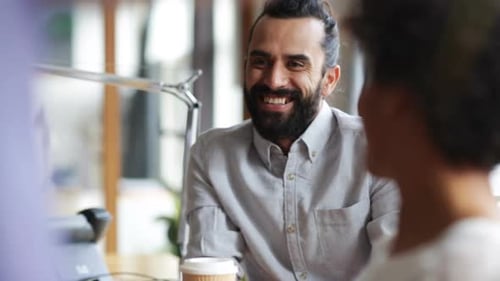 Man in gray shirt talking with colleagues