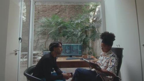 Coworkers Discussing Computer Code in Home Office