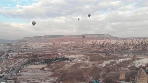 Hot air balloons fly over Goreme Valley in Cappadocia, Turkey - Ascending Wide Aerial