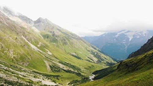 Breathtaking Green Valley with a River Flowing Through Majestic Mountains