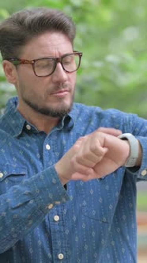 Man Outdoors Checks Smartwatch in Natural Light