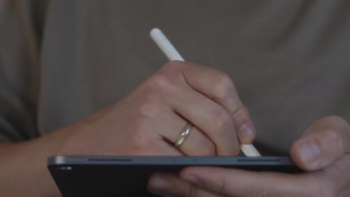 Man Using Stylus on Tablet Device Indoors