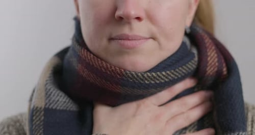 Woman Treating a Sore Throat with Spray
