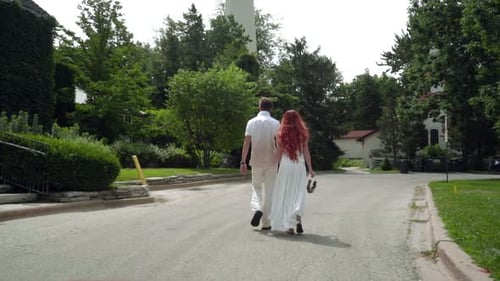 Love Couple Walking in Park. Couple in Love Holding Hands Together. Rear