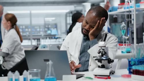 Scientist Working on Laptop in Modern Lab