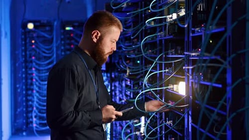 Server Technician Examining Modern Data Racks