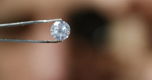 Round Cut Diamond Held in Tweezers
