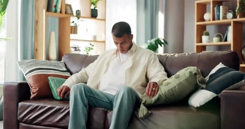 Man Relaxes on Couch in Bright Living Room