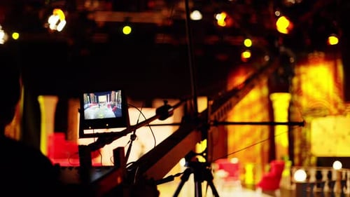 Man filming with professional camera on the backstage of a TV set