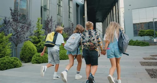 Group of cheerful energetic students child girl boy go to modern campus school with school backpacks