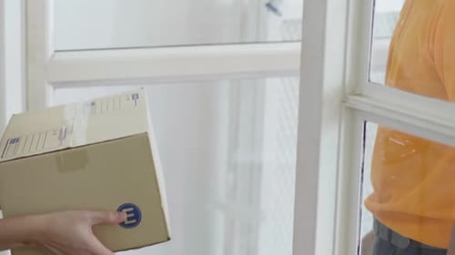 Woman Receiving Package from Delivery Man at Doorway