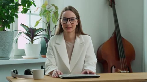 Woman at Desk Smiling with Laptop in Home Setting