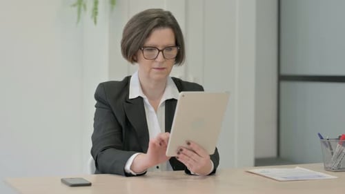 Old Businesswoman Celebrating Win on Digital Tablet