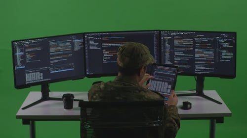 Man Soldier Developer Working With Tablet While Write Code With Multiple Screens In Green Screen