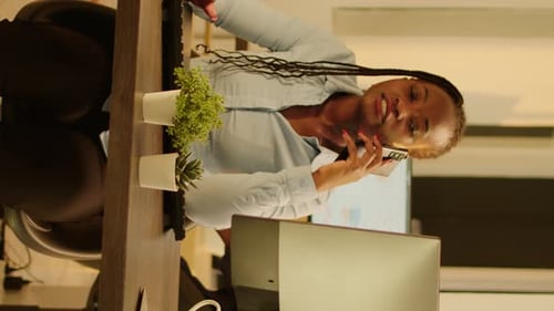 Businesswoman Talking on Mobile Phone in Office