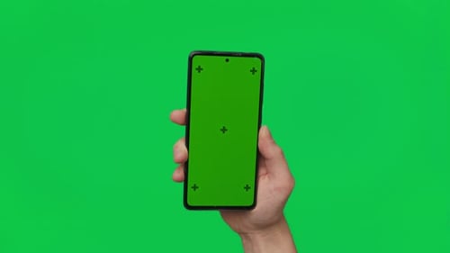 Male Hand Holding a Smartphone with Vertical Green Chroma Key Screen Isolated on Green Mobile Phone