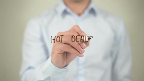 Person Writes Hot Deals on a Clear Surface