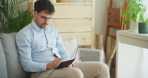 Businessman Organizes Meetings in Notebook