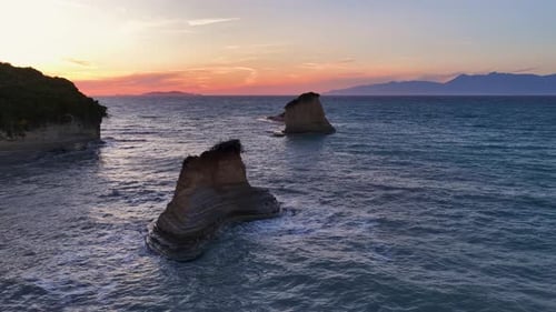 Captivating Corfu Coastal Sunset: Serene seascape with unique rock formations, gentle waves, and a v