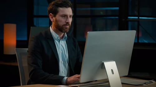 Man Typing on Computer Keyboard in Modern Office
