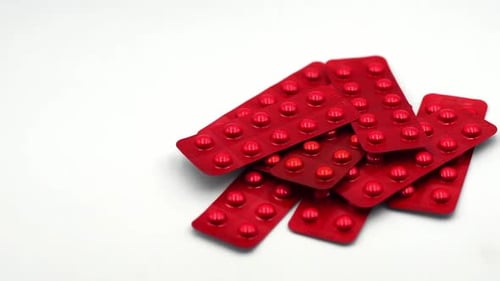 Red Pills in Blister Packs on White Background