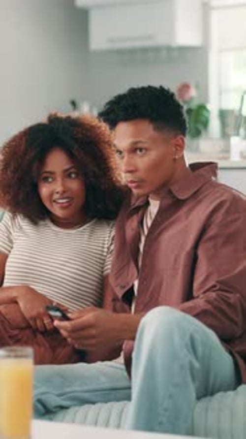 Couple Relaxing on Couch with Remote Control