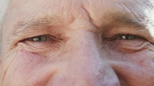Portrait of close up of eyes of happy unaltered senior caucasian man, in slow motion