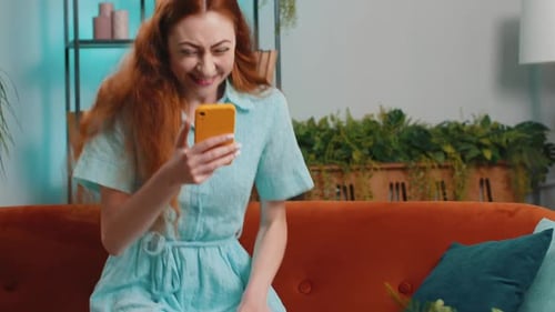 Woman Reacting with Joy While Using Smartphone