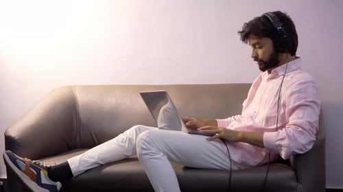 Man Using Laptop While Sitting on Couch
