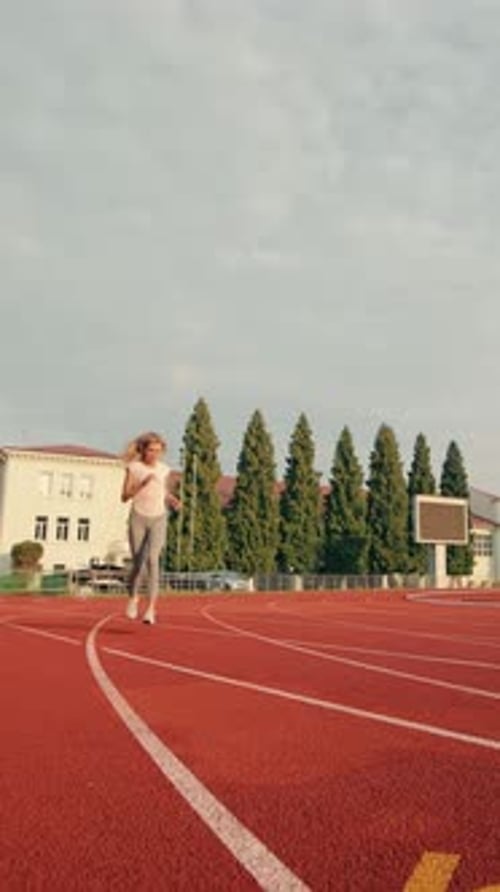 Woman jogging on an outdoor track daytime