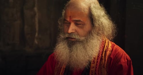 Slow Motion Close Up Portrait of Old Indian Monk Chanting in an Ancient Temple. Senior Guru Singing