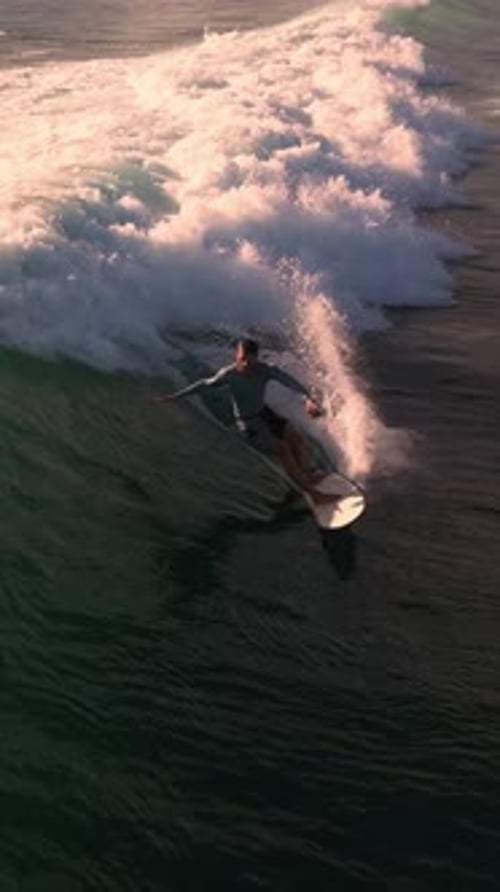 Surfer Rides Ocean Wave on Surfboard, Aerial View