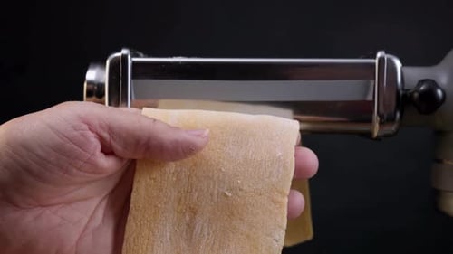 Pasta Dough being Rolled through Machine