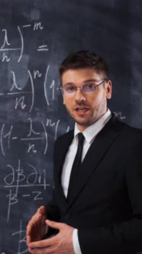 Adult Man Explaining Math in front of Chalkboard