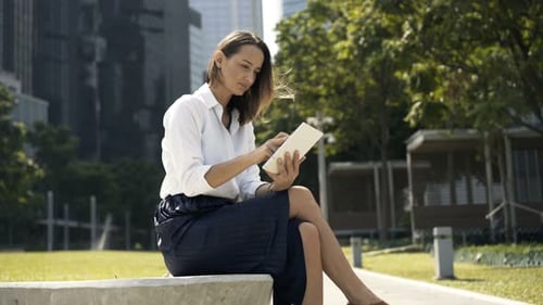 Young Pretty Businesswoman Using Tablet Sitting in City 30s