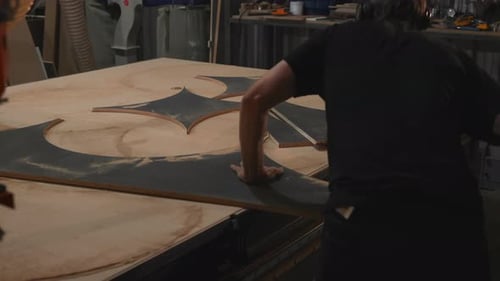 Focused Craftsman Meticulously Positions Complex Starshaped Inlay Within Round Plywood Panel In