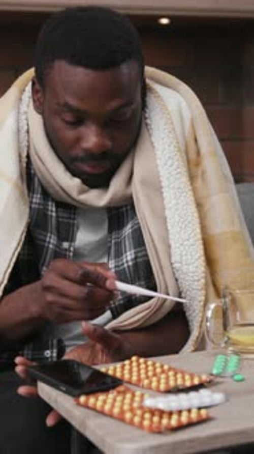 Cozy Indoor Moments A Man Taking Time to Reflect While Comfortably Wrapped in a Blanket