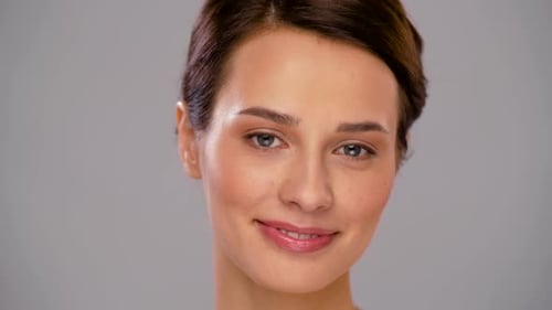 Smiling woman portrait on grey background, beauty concept