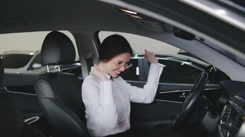 Enthusiastic Woman Celebrating in a Car Dealership