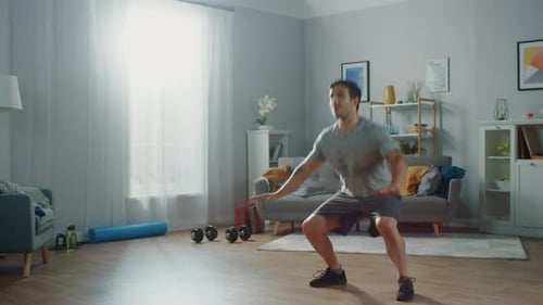 Athletic Man Doing Side-to-Side Jumps in Bright Home