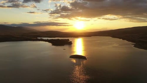 Vue aérienne du lac et des collines au coucher du soleil